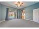 Bright primary bedroom with neutral carpet, ceiling fan, and sliding glass doors to the backyard pool at 2158 High Mesa Dr, Henderson, NV 89012