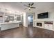 Open-concept living space with hardwood floors, fireplace, and modern kitchen featuring gray cabinets and stainless steel appliances at 2158 High Mesa Dr, Henderson, NV 89012