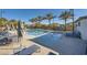 Community pool featuring lounge chairs, tables with umbrellas, and palm trees creating a resort-like atmosphere at 25 Barbara Ln # 42, Las Vegas, NV 89183