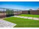 Backyard features a manicured lawn, paver patio and walkway, and an iron fence at 2577 Tolmezzo St, Henderson, NV 89044