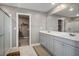 Bathroom with double vanity, shower, walk in closet, gray walls, and tile floors at 2577 Tolmezzo St, Henderson, NV 89044