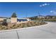 Sunny view of the Inspitada community entrance sign, surrounded by landscaping, with homes visible in the background at 2577 Tolmezzo St, Henderson, NV 89044