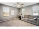 Spacious living room with neutral carpet, large windows offering natural light, and a gray sofa at 2577 Tolmezzo St, Henderson, NV 89044