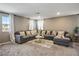 Spacious living room with a comfortable sectional couch and plush carpet at 2577 Tolmezzo St, Henderson, NV 89044
