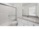Modern bathroom with white cabinets, granite countertop, and glass enclosed shower with white tiling at 2618 Lily Point St, Las Vegas, NV 89156