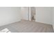 Bright bedroom with neutral carpet and ensuite bathroom access through a white paneled door at 2618 Lily Point St, Las Vegas, NV 89156