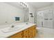 Bright bathroom with a double sink vanity, large mirror, and combined shower and tub with glass doors at 3320 Indian Moon Dr, Las Vegas, NV 89129