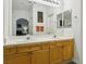 Bright bathroom with a double sink vanity and large mirror reflecting a view into the adjacent bedroom at 3320 Indian Moon Dr, Las Vegas, NV 89129