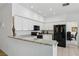 Open concept kitchen featuring white cabinets, granite countertops, and black appliances at 3320 Indian Moon Dr, Las Vegas, NV 89129