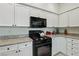 Well-lit kitchen features granite countertops and white cabinets, complemented by modern appliances at 3320 Indian Moon Dr, Las Vegas, NV 89129