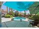 A backyard view of a private swimming pool surrounded by lush greenery, palm trees, and patio space at 3320 Indian Moon Dr, Las Vegas, NV 89129