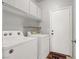 Efficient laundry room equipped with a washer, dryer, overhead cabinets, and access to an outdoor space at 3389 Commendation Dr, Las Vegas, NV 89117