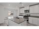 Modern kitchen featuring an island with a sink, stainless steel appliances, and stone countertops at 4253 Gold Desert St, North Las Vegas, NV 89032