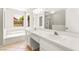 Bright bathroom with double sinks, a soaking tub, and a large mirror at 4324 Peaceful Path Ct, North Las Vegas, NV 89032