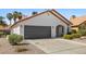 View of the home with a two-car garage, stucco exterior, and desert landscaping at 4324 Peaceful Path Ct, North Las Vegas, NV 89032