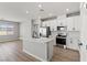 Well-lit kitchen featuring white cabinets, stainless steel appliances, a marble countertop island, and wood-look flooring at 4433 Pioche Ave, North Las Vegas, NV 89032
