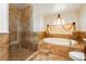 Bathroom featuring a large soaking tub, tiled shower, and glass surround at 4620 N Tee Pee Ln, Las Vegas, NV 89129