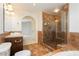 Well-lit bathroom features a glass shower, built-in tub, arched doorway and unique tile work at 4620 N Tee Pee Ln, Las Vegas, NV 89129