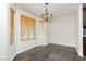 Cozy dining room with chandelier, with window and stone floors, adjoining kitchen area at 4620 N Tee Pee Ln, Las Vegas, NV 89129