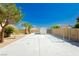 Long concrete driveway with a chain link fence, drought tolerant landscaping, and mature trees at 4620 N Tee Pee Ln, Las Vegas, NV 89129
