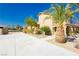 Two-story home with drought tolerant landscaping, palm trees, and white concrete driveway at 4620 N Tee Pee Ln, Las Vegas, NV 89129