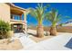 Two-story home with drought tolerant landscaping, sidewalks, and palm trees at 4620 N Tee Pee Ln, Las Vegas, NV 89129