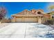 Exterior shot of a desert home with an attached three car garage and xeriscaped yard at 4620 N Tee Pee Ln, Las Vegas, NV 89129