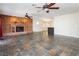 Spacious living room with brick fireplace, ceiling fans, and stone floors at 4620 N Tee Pee Ln, Las Vegas, NV 89129