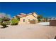Exterior side view of a desert home with a spacious parking area and neutral color scheme at 4620 N Tee Pee Ln, Las Vegas, NV 89129