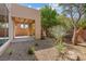 This backyard features desert landscaping with a covered patio, block wall, trees, and shrubs at 5603 Deer Creek Falls Ct, Las Vegas, NV 89118