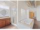 Bright bathroom featuring a soaking tub, glass-enclosed shower, and vanity with modern fixtures at 5603 Deer Creek Falls Ct, Las Vegas, NV 89118