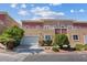 Townhouse with a two-car garage, balcony, manicured bushes, and a stucco exterior in a residential area at 5603 Deer Creek Falls Ct, Las Vegas, NV 89118