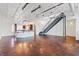 Large living space featuring polished concrete floors, exposed beams, staircase, and a partial kitchen view at 5603 Deer Creek Falls Ct, Las Vegas, NV 89118