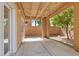 This covered patio features a concrete base with a view of the landscaped yard and an indoor door and window at 5603 Deer Creek Falls Ct, Las Vegas, NV 89118