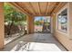This covered patio features a concrete base with a view of the landscaped yard and an indoor door and window at 5603 Deer Creek Falls Ct, Las Vegas, NV 89118