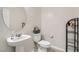 Elegant half bathroom featuring modern fixtures, pedestal sink, and stylish mirror at 5660 Oasis Ridge St, North Las Vegas, NV 89031