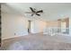 Spacious living room with neutral carpet, ceiling fan, and plenty of natural light at 5660 Oasis Ridge St, North Las Vegas, NV 89031