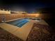In-ground pool with hot tub, ambient string lights, privacy wall, and desert landscaping at night at 5660 Oasis Ridge St, North Las Vegas, NV 89031