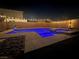 In-ground pool with hot tub lit with blue lights, string lights and desert landscaping at night at 5660 Oasis Ridge St, North Las Vegas, NV 89031