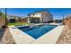 Inviting in-ground pool with adjacent spa, landscaping, view of the home's exterior, and privacy wall at 5660 Oasis Ridge St, North Las Vegas, NV 89031
