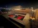 Night view of the in-ground pool and hot tub, featuring color lights and desert landscaping at 5660 Oasis Ridge St, North Las Vegas, NV 89031