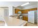 Well-lit kitchen featuring oak cabinets, a breakfast bar, and white appliances at 5855 Valley Dr # 2145, North Las Vegas, NV 89031