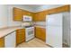 Cozy kitchen with oak cabinets, white appliances, and light wood-look flooring at 5855 Valley Dr # 2145, North Las Vegas, NV 89031