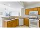 Well-lit kitchen featuring a breakfast bar, stainless steel sink, and white appliances at 5855 Valley Dr # 2145, North Las Vegas, NV 89031