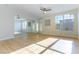 Bright living room with wood laminate floors, a ceiling fan, a big mirror, and plenty of sunlight from the window at 5855 Valley Dr # 2145, North Las Vegas, NV 89031