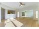 Open-concept living room with wood laminate floors, a big mirror, modern lighting, and an adjacent kitchen area at 5855 Valley Dr # 2145, North Las Vegas, NV 89031