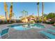 Community pool with a jacuzzi surrounded by lush landscaping, seating, and a building with a red tile roof at 5855 Valley Dr # 2145, North Las Vegas, NV 89031