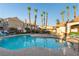 Community pool featuring tall palm trees, a jacuzzi, and ample seating for residents' relaxation and enjoyment at 5855 Valley Dr # 2145, North Las Vegas, NV 89031