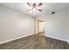 Bright bedroom with wood-look flooring, ceiling fan, and doorway to hallway at 6160 Rumrill St # 215, Las Vegas, NV 89113