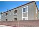 Apartment building exterior with a brick wall, showing units and balconies at 6160 Rumrill St # 215, Las Vegas, NV 89113